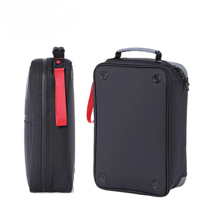 A black soft-sided rectangular travel or luggage bag shown from two angles on a white background: a side view with a red zipper pull tab and a top handle, and a front view with the same red tab visible at the side.