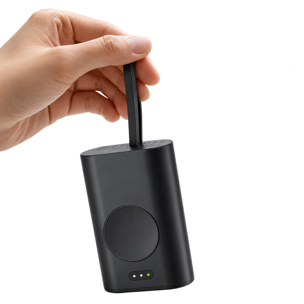A hand holds the black built-in strap of a cylindrical portable power bank, in a clean light background.