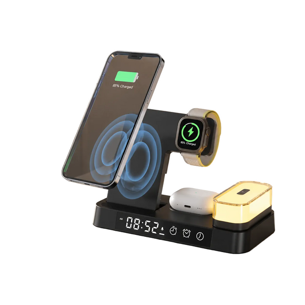 A black multi-device wireless charging stand placed on a light stone tabletop in a warm indoor setting. The stand holds a smartphone on a tilted charging pad, a smartwatch on a horizontal charging arm, a white earbud case, and a small rectangular charging dock with a glowing warm light.